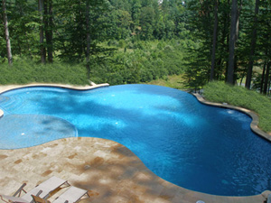 Beautiful Swimming Pool Designs with Travertine Pavers and Waterfall