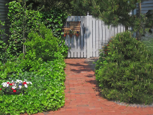 Brick walk leads to backyard gate.