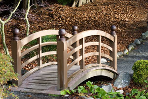 A decorative garden bridge is nice in the landscape.