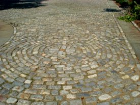 Driveway cobblestones in a circular pattern.